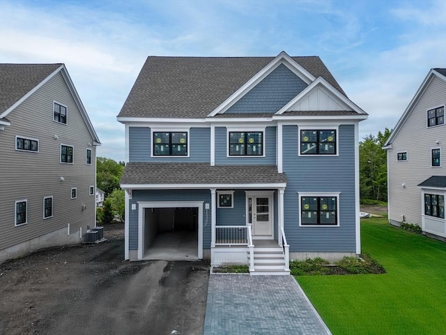 view of front of home featuring a porch, roof with shingles, asphalt driveway, a garage, and a front lawn