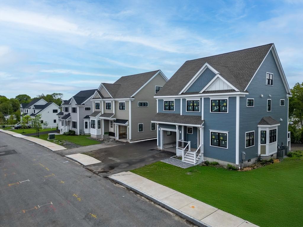 view of property featuring a garage, driveway, a residential view, and a front lawn
