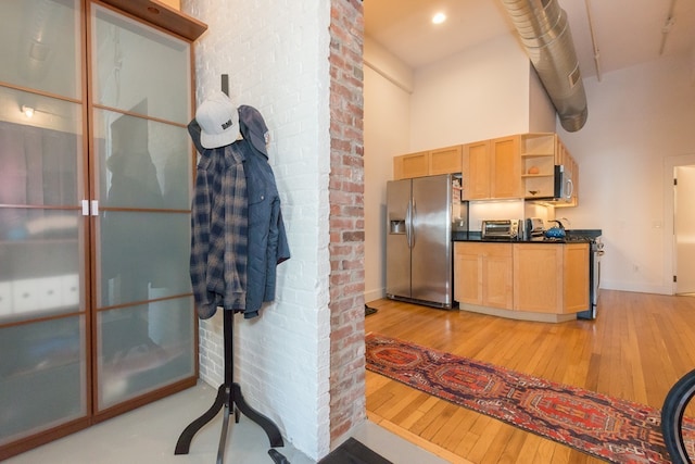 kitchen featuring open shelves, dark countertops, baseboards, light wood-style flooring, and appliances with stainless steel finishes