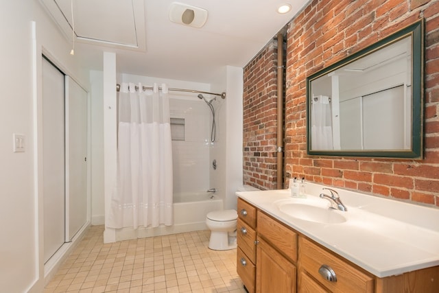 bathroom with vanity, tile patterned floors, brick wall, and toilet