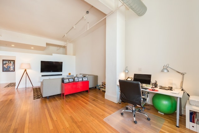 office featuring rail lighting and hardwood / wood-style flooring