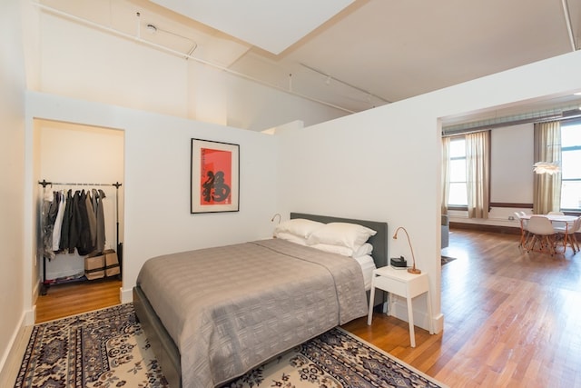 bedroom with lofted ceiling and wood finished floors