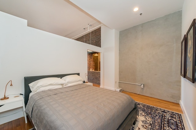 bedroom featuring a high ceiling and wood finished floors
