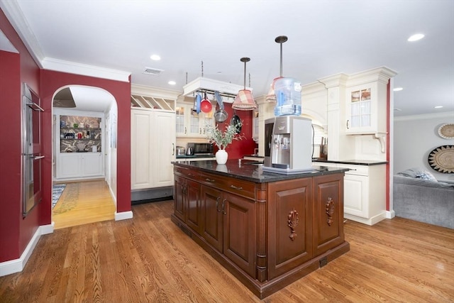 20 Albee Dr, Braintree, MA 02184 - kitchen with arched walkways, a center island, ornamental molding, glass insert cabinets, and light wood-type flooring