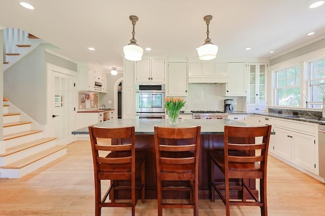 5 Baxter St, Westborough, MA 01581 - kitchen featuring backsplash, white cabinets, recessed lighting, light wood finished floors, and a kitchen island