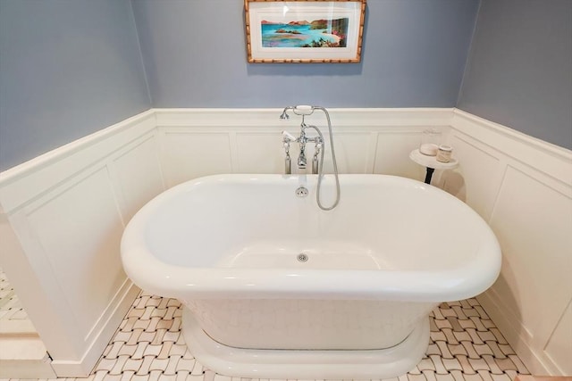 5 Baxter St, Westborough, MA 01581 - bathroom featuring a decorative wall, a soaking tub, wainscoting, and tile patterned floors