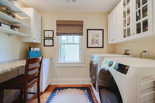 5 Baxter St, Westborough, MA 01581 - laundry area featuring cabinet space, washer and clothes dryer, baseboards, and light wood-style flooring