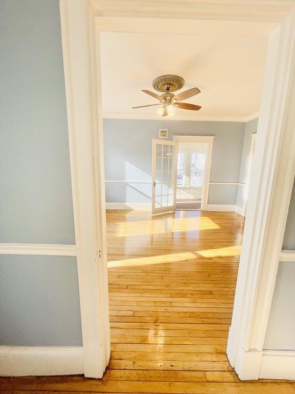 hallway with hardwood / wood-style flooring and crown molding