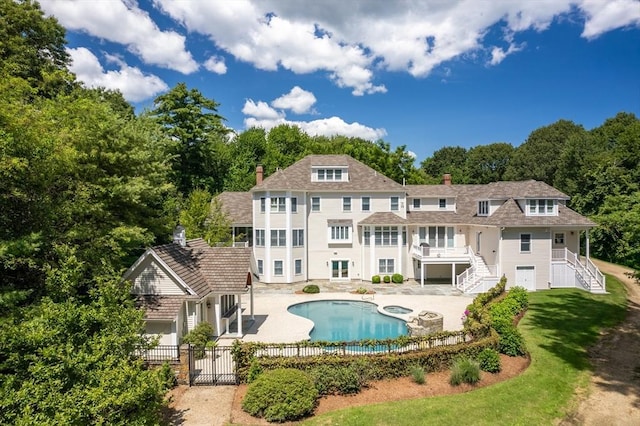 back of house with a yard, a fenced in pool, and a patio area