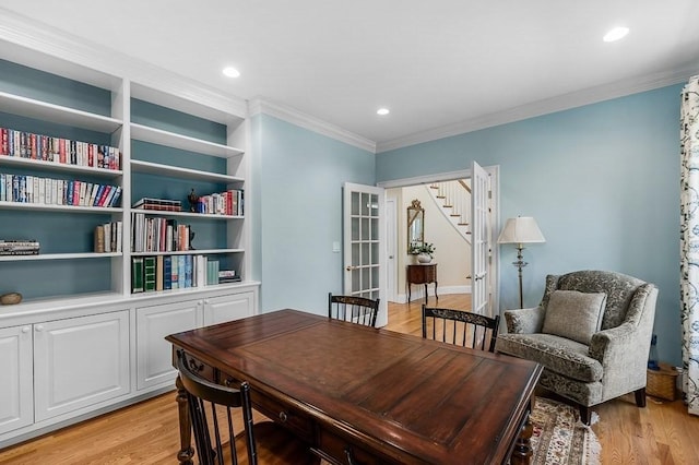 office space with crown molding, built in features, and light hardwood / wood-style floors