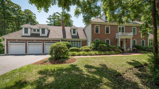 view of front of house with a balcony, a garage, and a front lawn