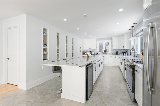 kitchen with a spacious island, sink, white cabinetry, stainless steel appliances, and light stone countertops