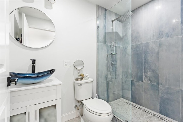 bathroom featuring vanity, tiled shower, and toilet