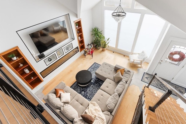 living room with hardwood / wood-style flooring, lofted ceiling, and a chandelier