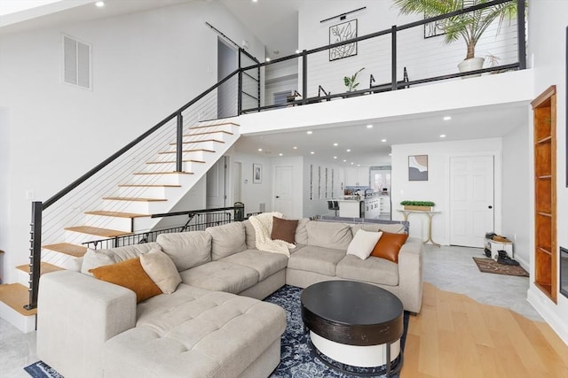 living room with light hardwood / wood-style floors and a high ceiling