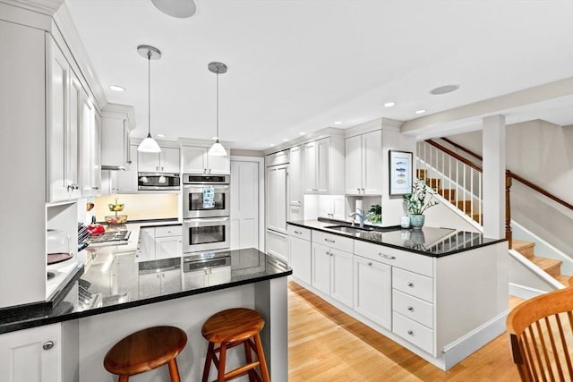 12 Braddock Park Unit 1, Boston, MA 02116 - kitchen featuring stainless steel appliances, a peninsula, recessed lighting, light wood-style flooring, and white cabinetry