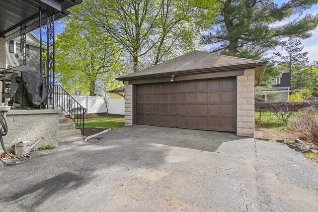 detached garage featuring fence