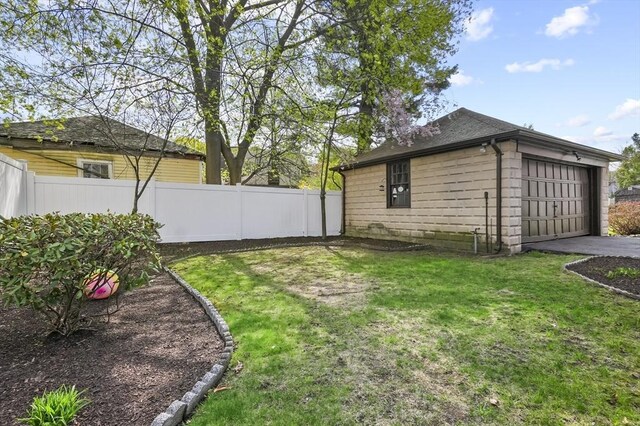 view of yard featuring fence, an attached garage, and driveway
