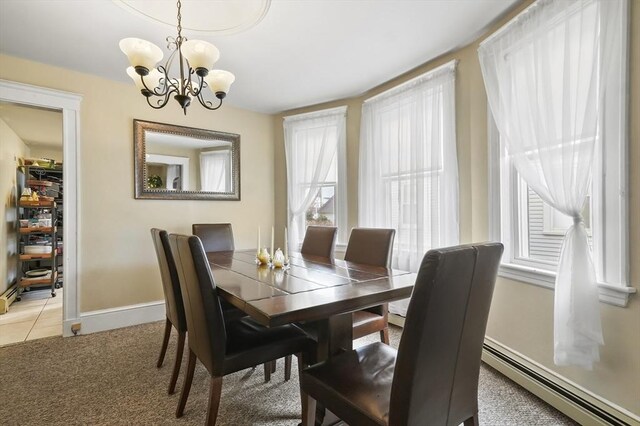dining area featuring baseboards, light colored carpet, a chandelier, a baseboard radiator, and light tile patterned floors