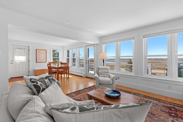 living room with recessed lighting, baseboards, baseboard heating, and light wood finished floors