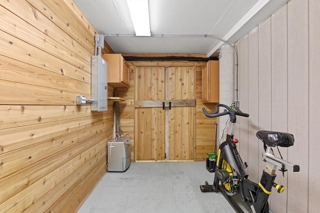 workout area featuring electric panel and wooden walls