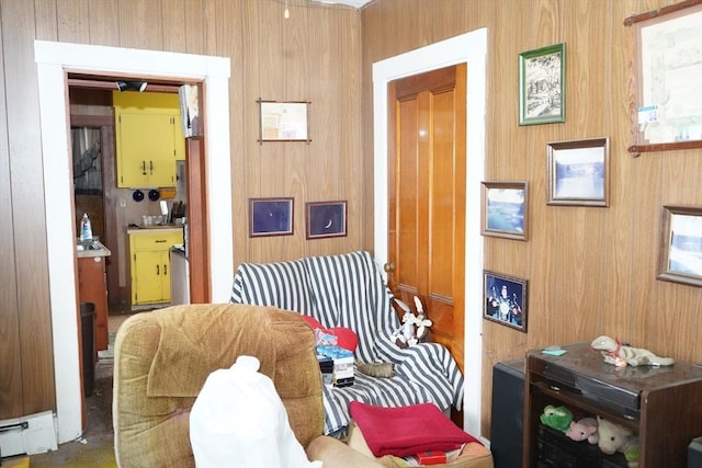 sitting room featuring baseboard heating and wood walls