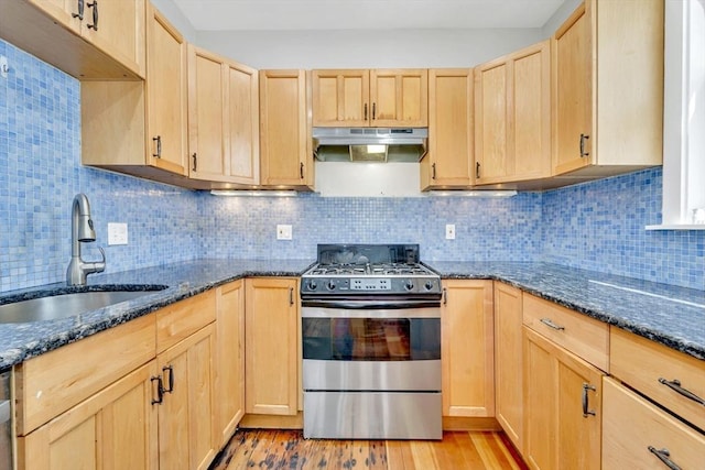 59 Bonair St, Somerville, MA 02145 - kitchen with stainless steel gas range oven, a sink, light brown cabinets, under cabinet range hood, and dark stone countertops