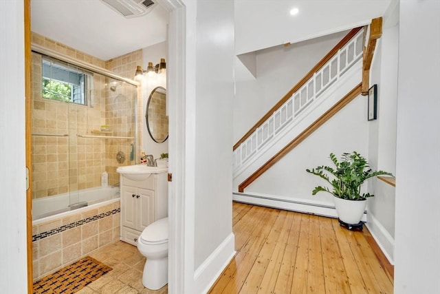 59 Bonair St, Somerville, MA 02145 - full bath featuring a baseboard heating unit, vanity, tiled shower / bath, toilet, and baseboards