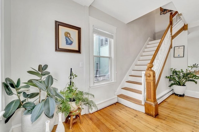 59 Bonair St, Somerville, MA 02145 - staircase featuring baseboard heating, baseboards, and wood finished floors