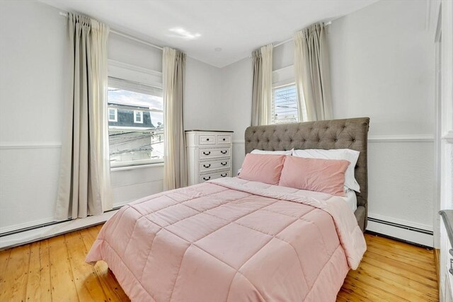 59 Bonair St, Somerville, MA 02145 - bedroom with a baseboard heating unit, multiple windows, and light wood finished floors