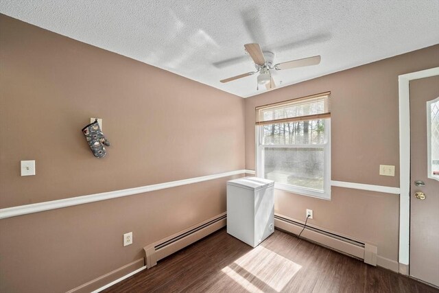 unfurnished room with a textured ceiling, ceiling fan, baseboard heating, and wood finished floors