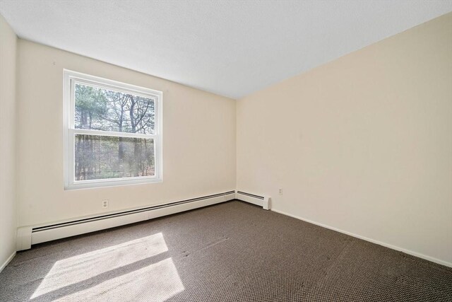 spare room featuring baseboards, a baseboard radiator, and carpet