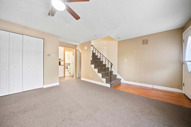 unfurnished living room featuring stairway, baseboards, carpet, and a ceiling fan
