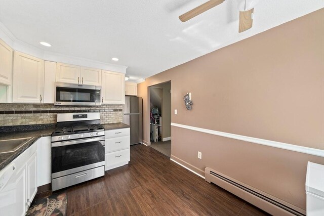 kitchen with dark countertops, appliances with stainless steel finishes, recessed lighting, tasteful backsplash, and a baseboard heating unit