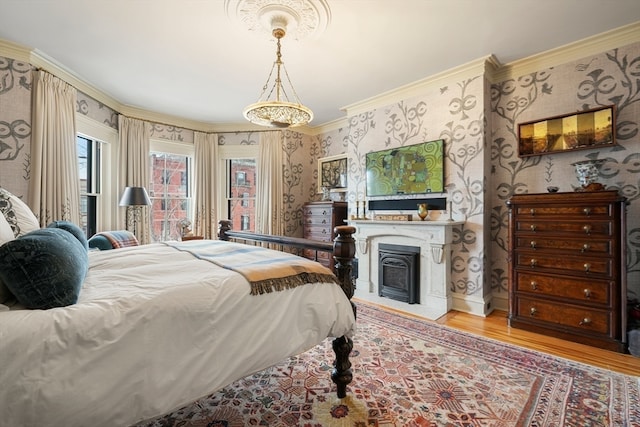 bedroom featuring ornamental molding and light hardwood / wood-style floors