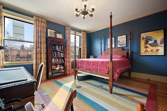 bedroom with a notable chandelier, light hardwood / wood-style flooring, and crown molding