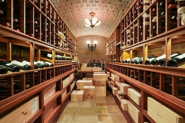 wine cellar featuring lofted ceiling, brick ceiling, and brick wall