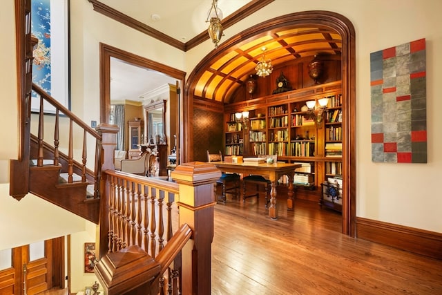 interior space featuring ornamental molding, lofted ceiling, an inviting chandelier, and wood-type flooring