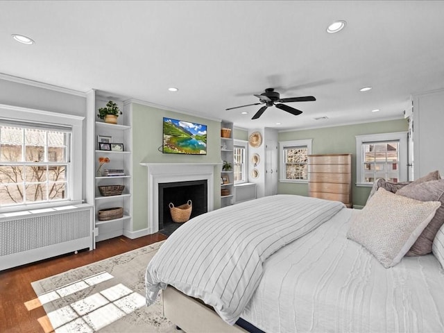 bedroom with recessed lighting, crown molding, radiator heating unit, and wood finished floors