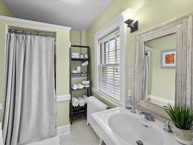 bathroom with radiator heating unit, a sink, and tile patterned floors