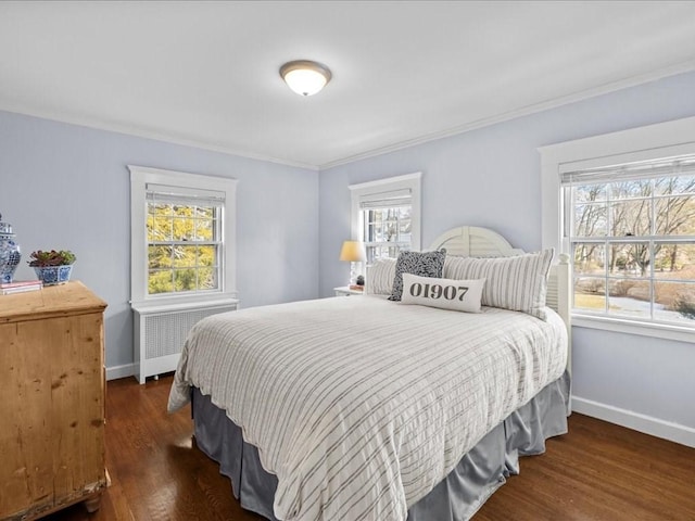 bedroom featuring radiator heating unit, wood finished floors, and baseboards