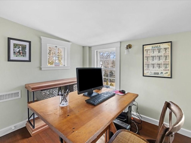 office space with dark wood finished floors, visible vents, and baseboards