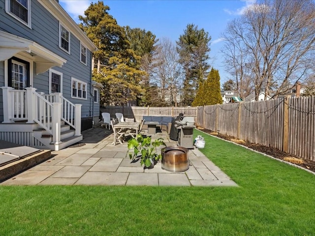 view of yard with a patio, a fenced backyard, and an outdoor living space with a fire pit