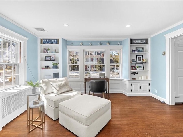 sitting room featuring visible vents, built in features, radiator, dark wood-type flooring, and crown molding