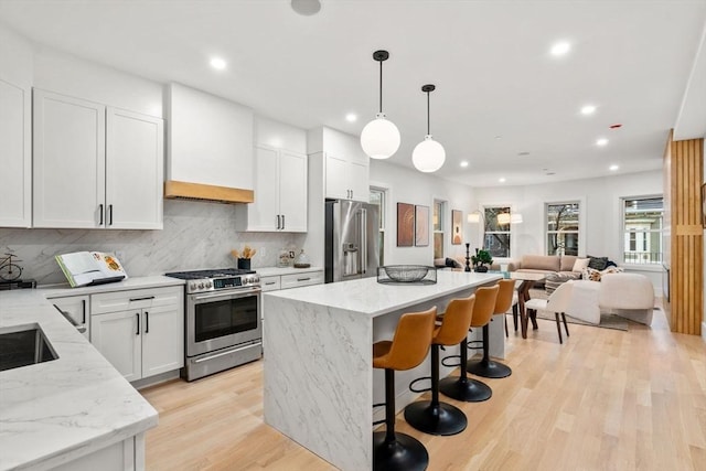 20 Boylston St Unit 3, Boston, MA 02130 - kitchen featuring appliances with stainless steel finishes, a center island, premium range hood, recessed lighting, and backsplash