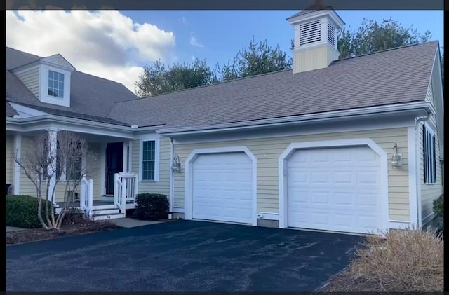 1 Hayloft Ln Unit 1, Marshfield, MA 02050 - view of front facade with driveway, an attached garage, roof with shingles, covered porch, and a chimney