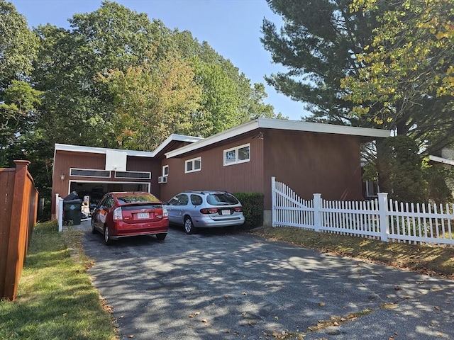 view of front of home featuring driveway and fence