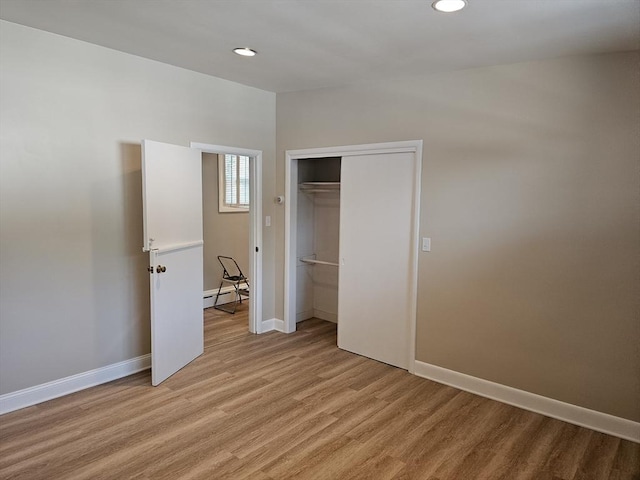 unfurnished bedroom featuring recessed lighting, light wood-type flooring, baseboards, and a baseboard radiator