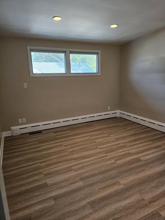 unfurnished room with recessed lighting, plenty of natural light, and dark wood-style flooring