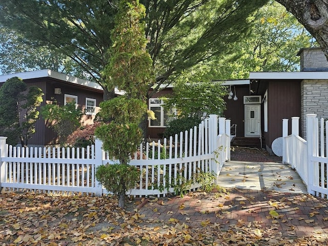 view of home's exterior with a fenced front yard and a chimney